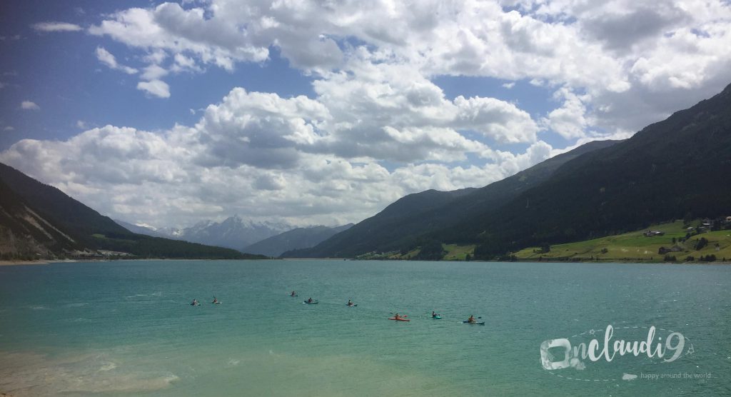 This is Lake Reschen, a lake in South Tyrol, Italy. Taking a kite surf lesson, a dip in the crystal clear water or renting a kayak for a tour on Lake Reschen is an amazing way of relaxation.
